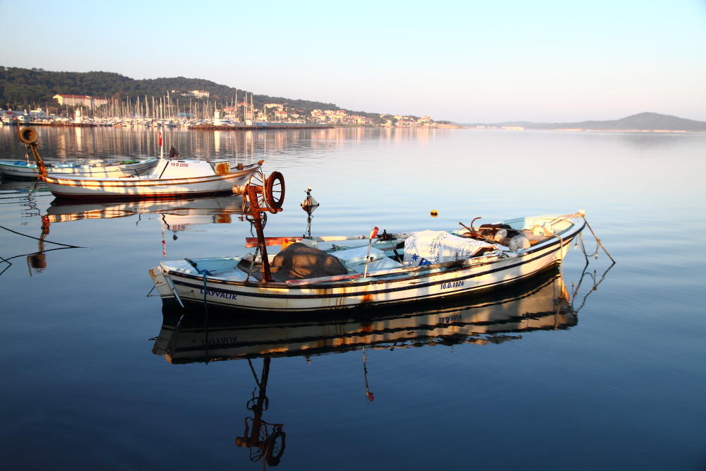 Ayvalık sahilini ve çarşaf gibi serilmiş serin Ege denizini yeni günün ilk ışıkları aydınlatıyor